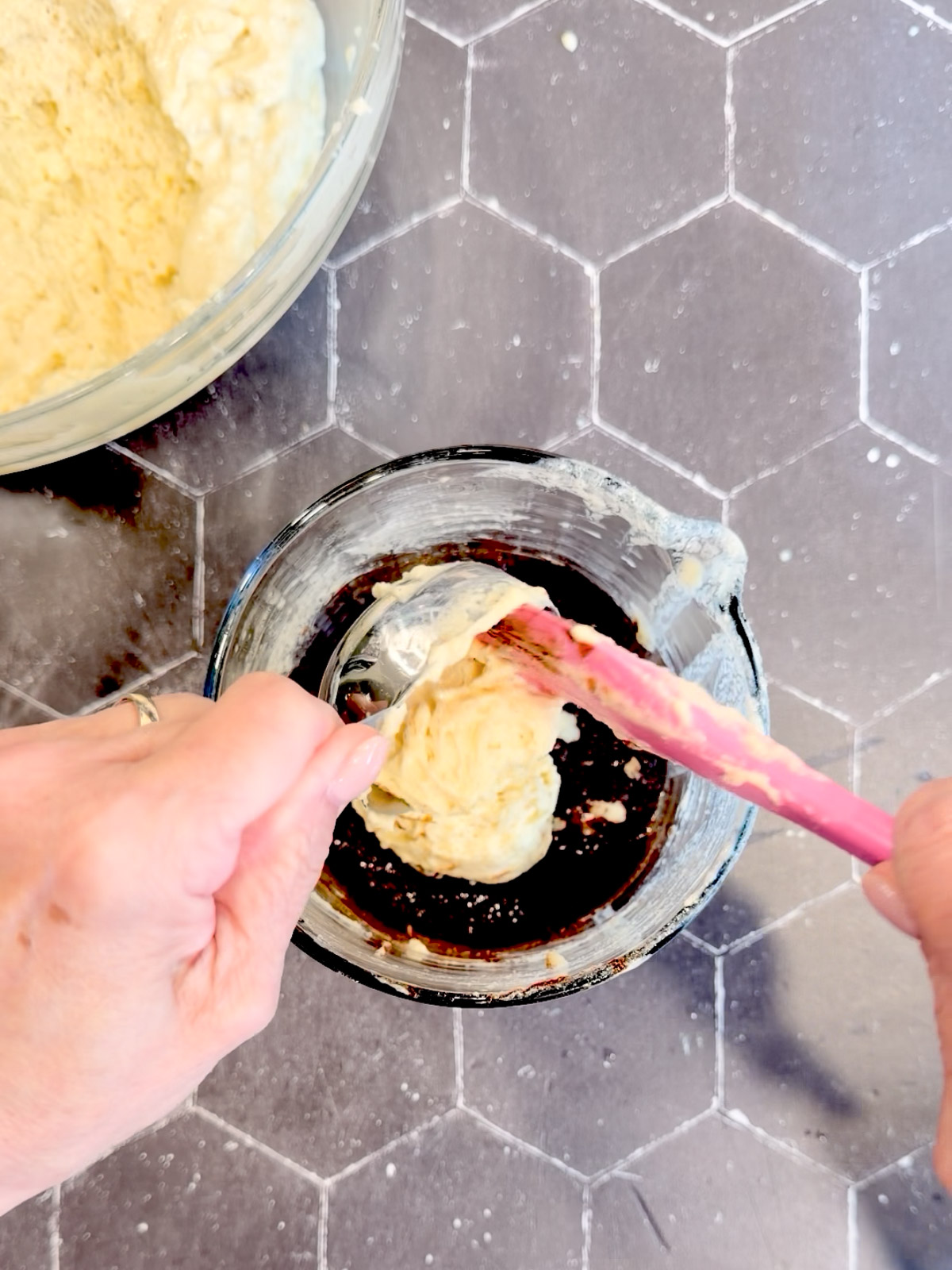Adding pancake batter to the cinnamon sugar filling in a measuring cup.