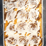 Cinnamon roll pancakes with cream cheese icing on a sheet pan.