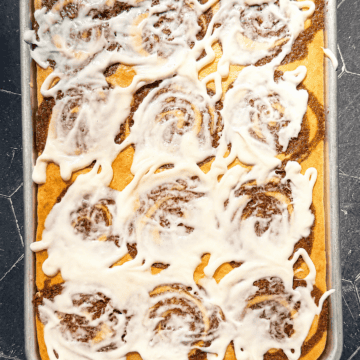 Cinnamon roll pancakes with cream cheese icing on a sheet pan.