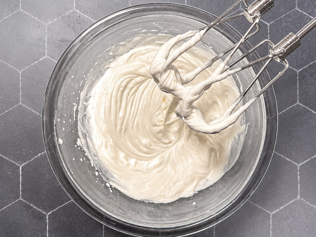Cream cheese frosting in a glass bowl.