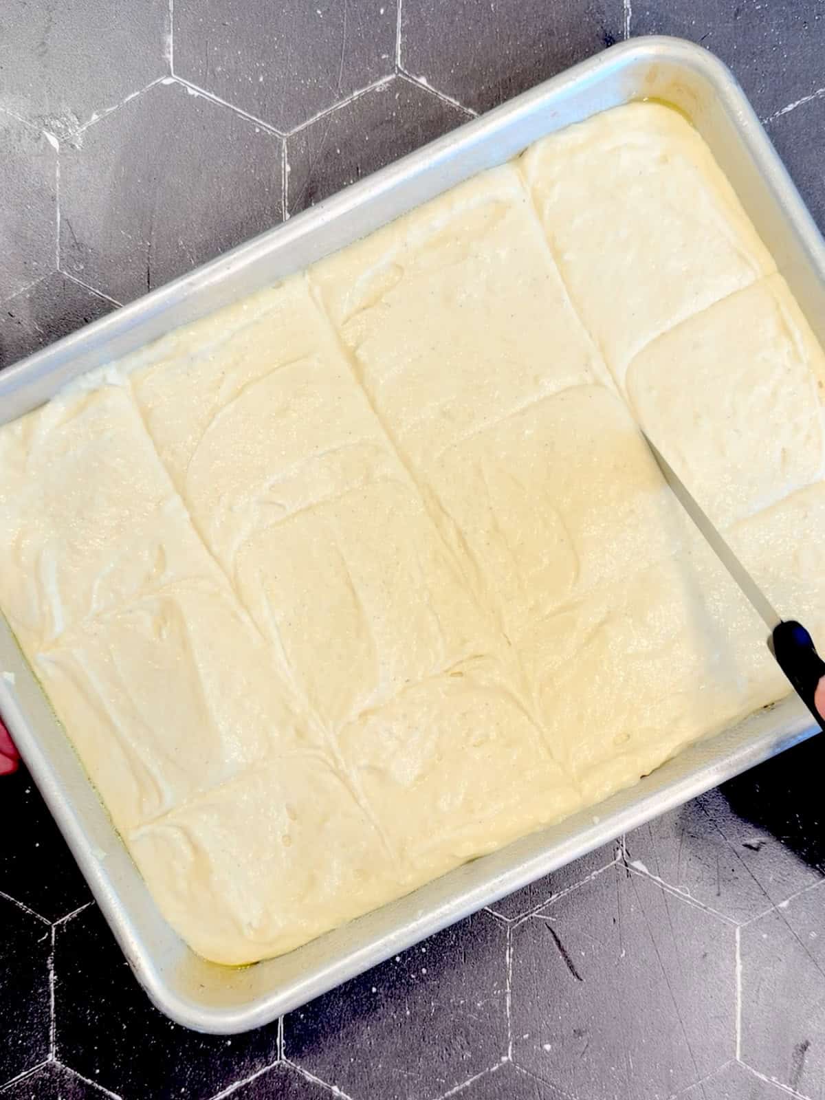 Using a pairing knife to score the top of pancake batter into 12 quadrants.