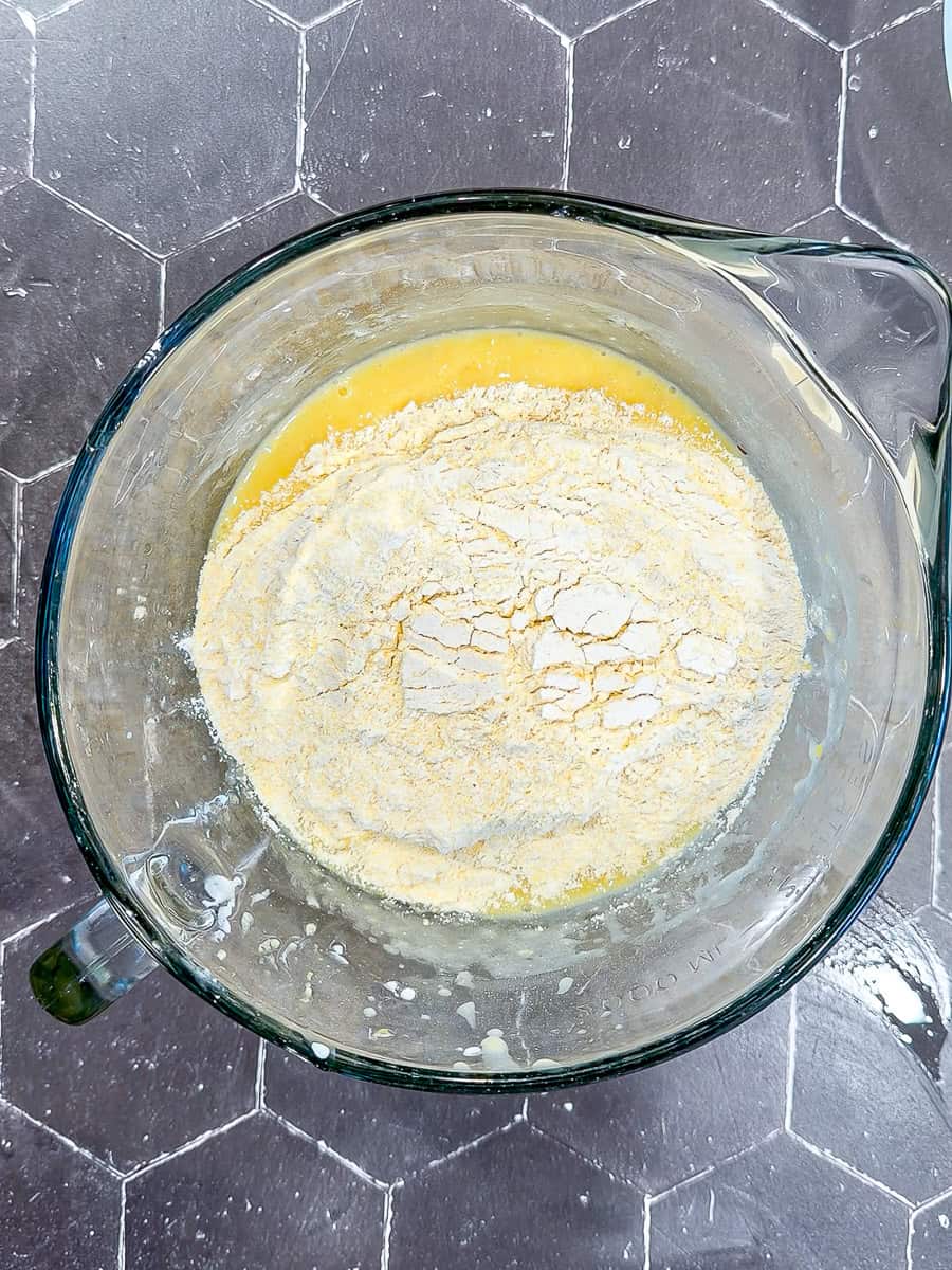 Adding dry ingredients to whisk wet ingredients in a large measuring pitcher.