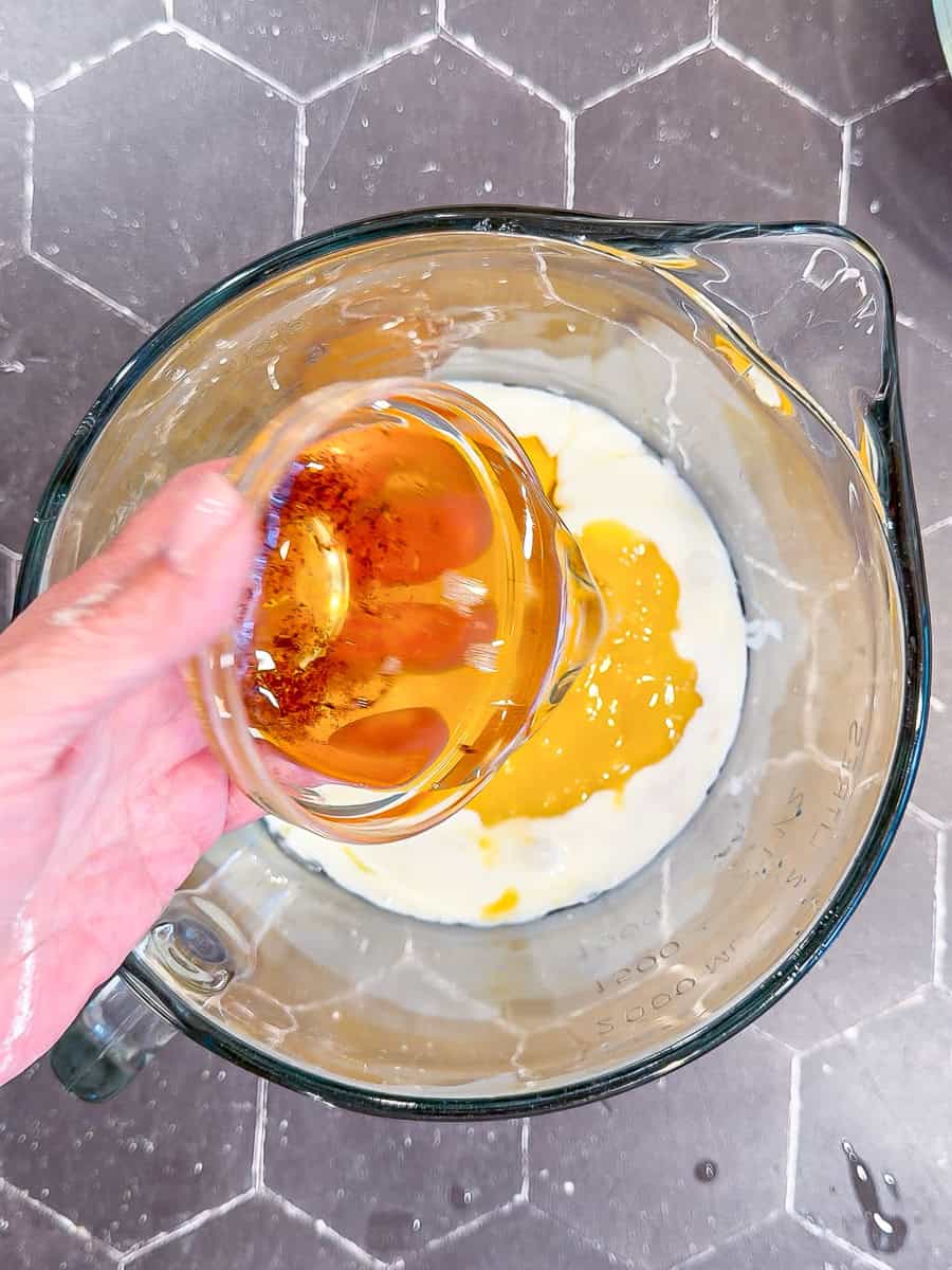 Measuring wet ingredients in a large measuring pitcher.
