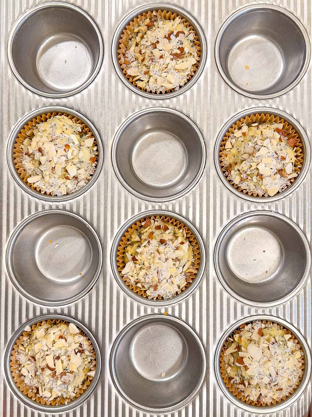 Unbaked muffins in a muffin pan.