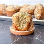 Side of view of an almond poppy seed muffin with a bite taken out.