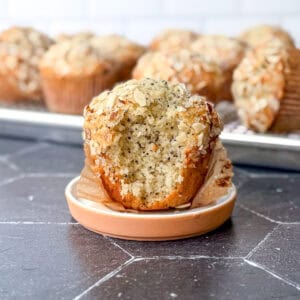 Side of view of an almond poppy seed muffin with a bite taken out.