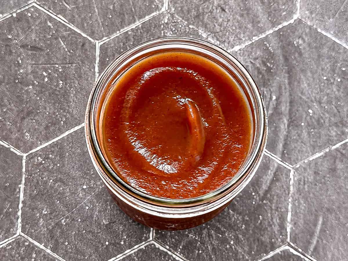 The swirled top of apple butter in a mason jar.