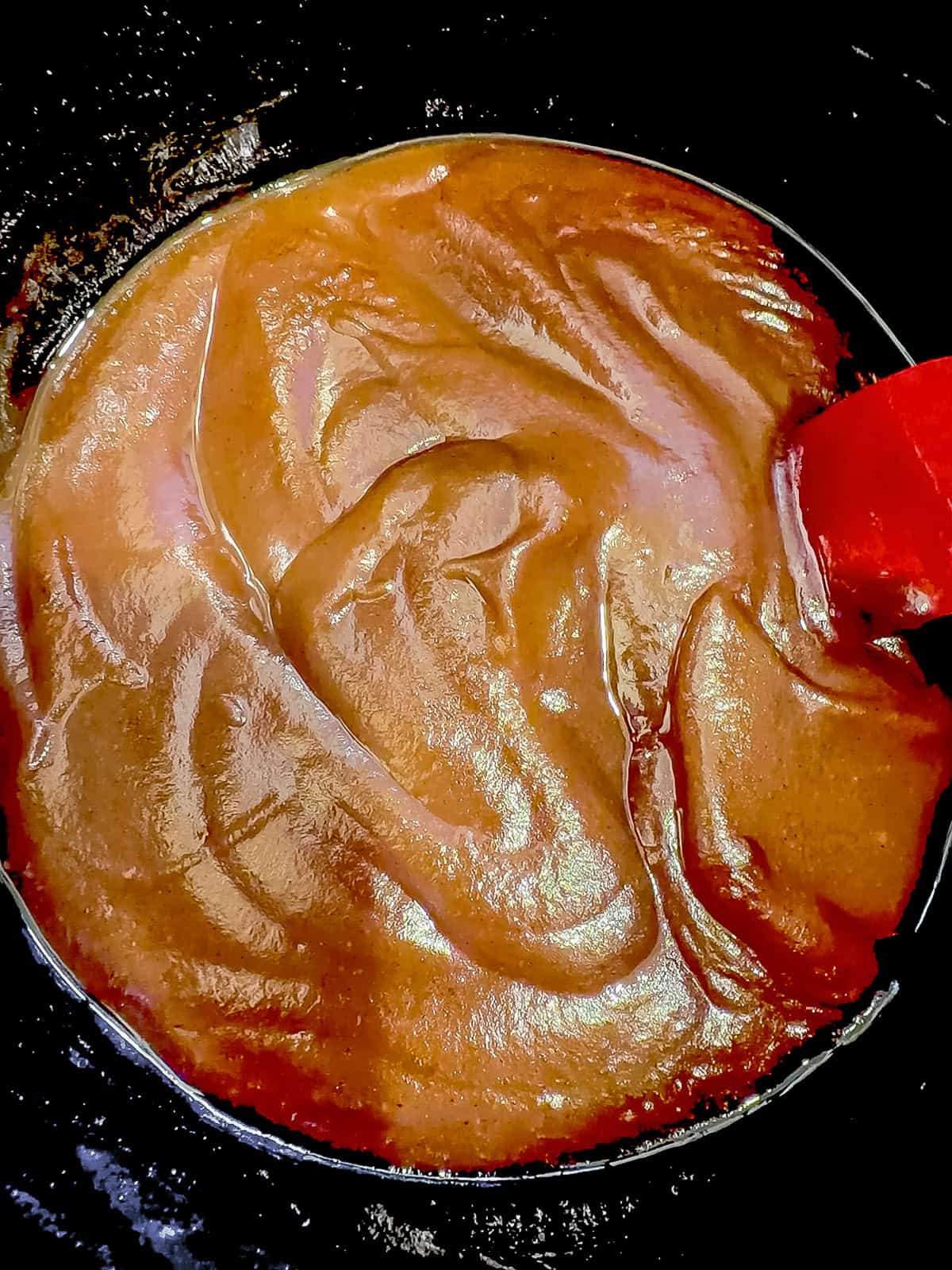 Puréed apple butter in the bottom of a slow cooker.