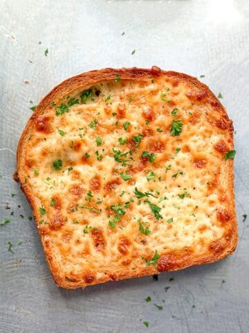 A piece of cheese toast on a sheet pan.