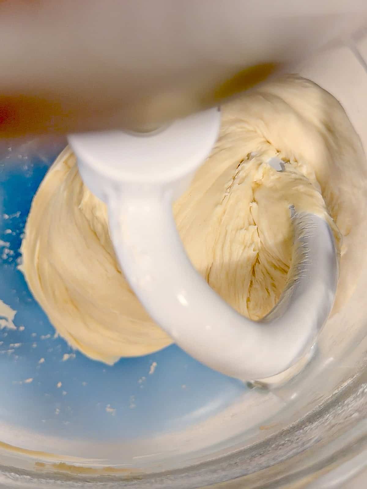 Donut dough in the bowl of a stand mixer.