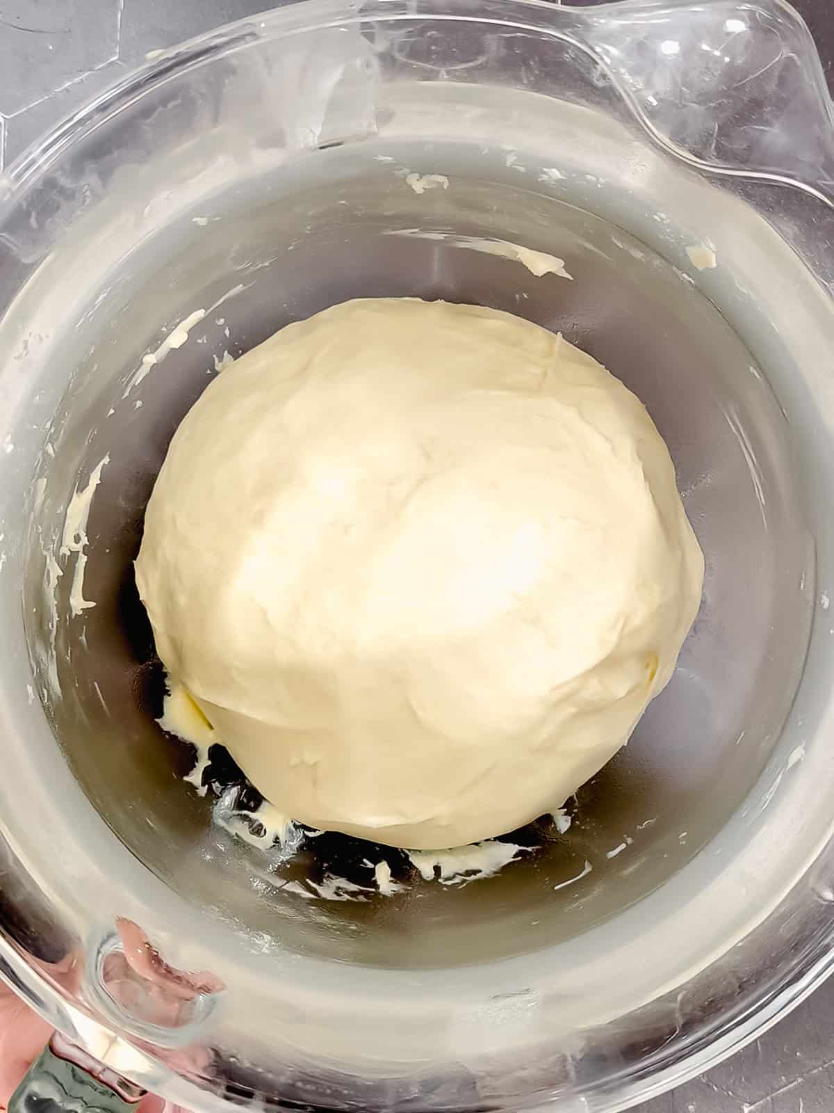 Donut dough in a glass bowl after rising.