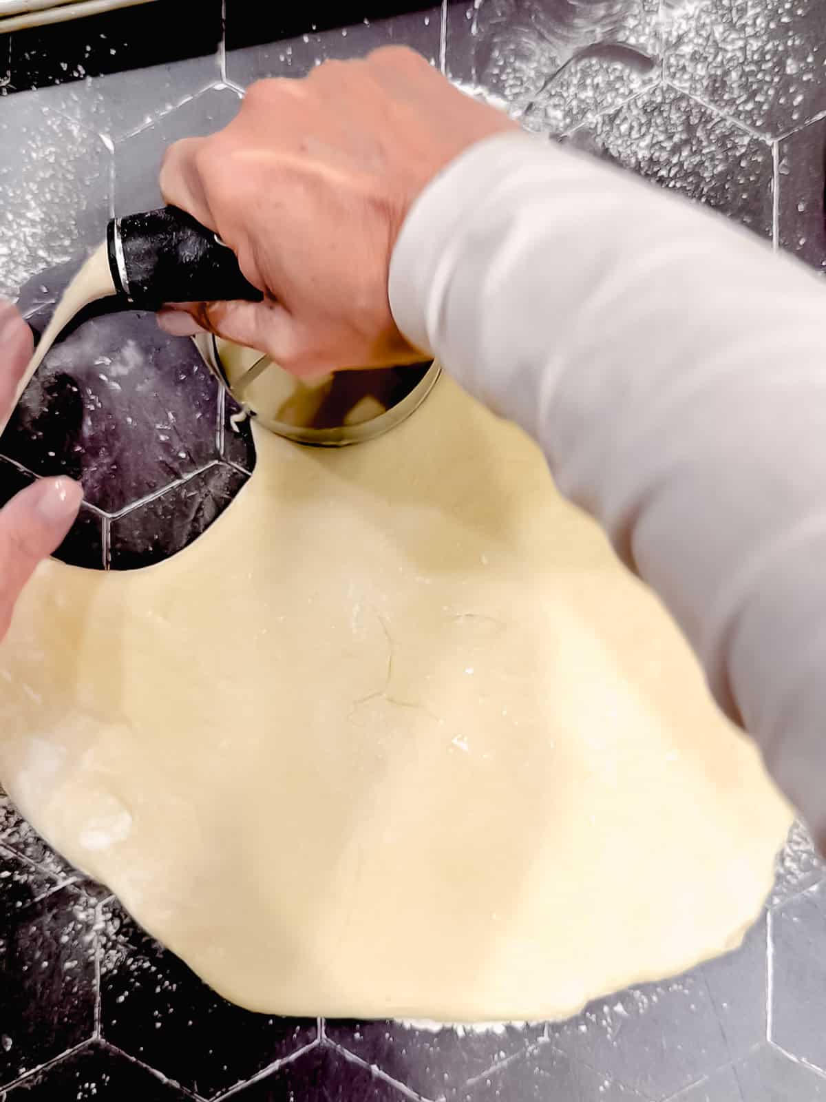 Cutting out donuts on a Black counter.