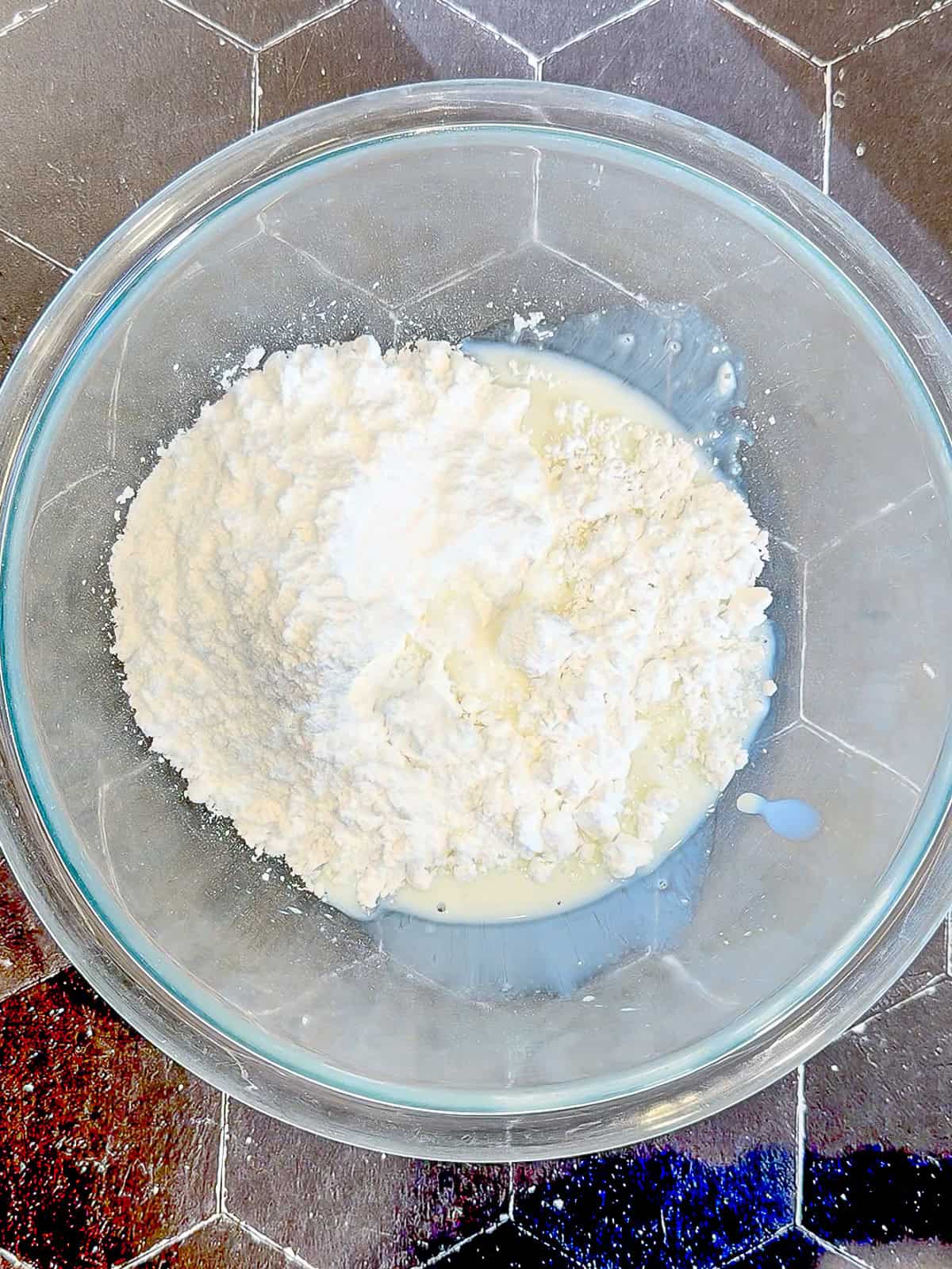 Ingredients to make a doughnut glaze in a glass bowl.