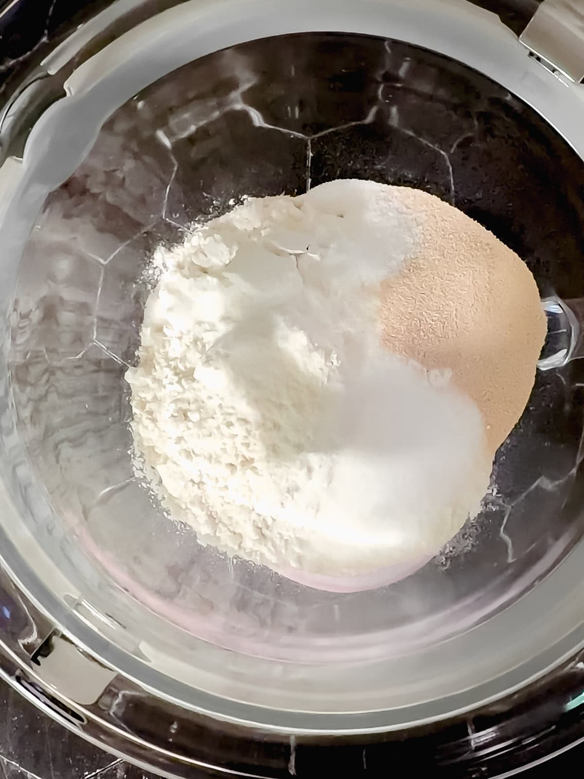 Dry ingredients to make classic glazed donuts in a glass bowl.