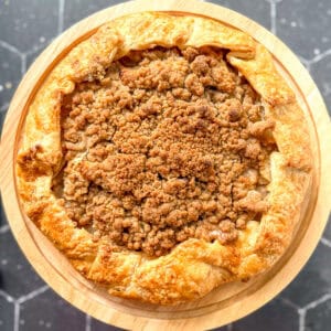 Apple streusel galette on a cake stand.