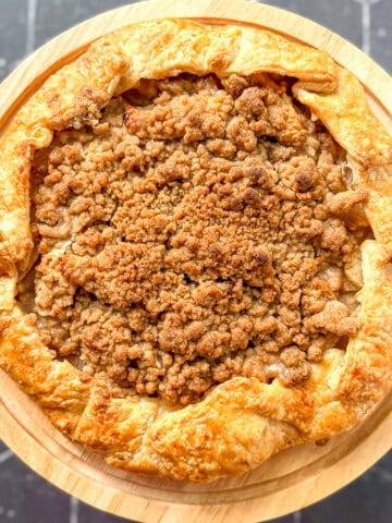 Apple streusel galette on a cake stand.