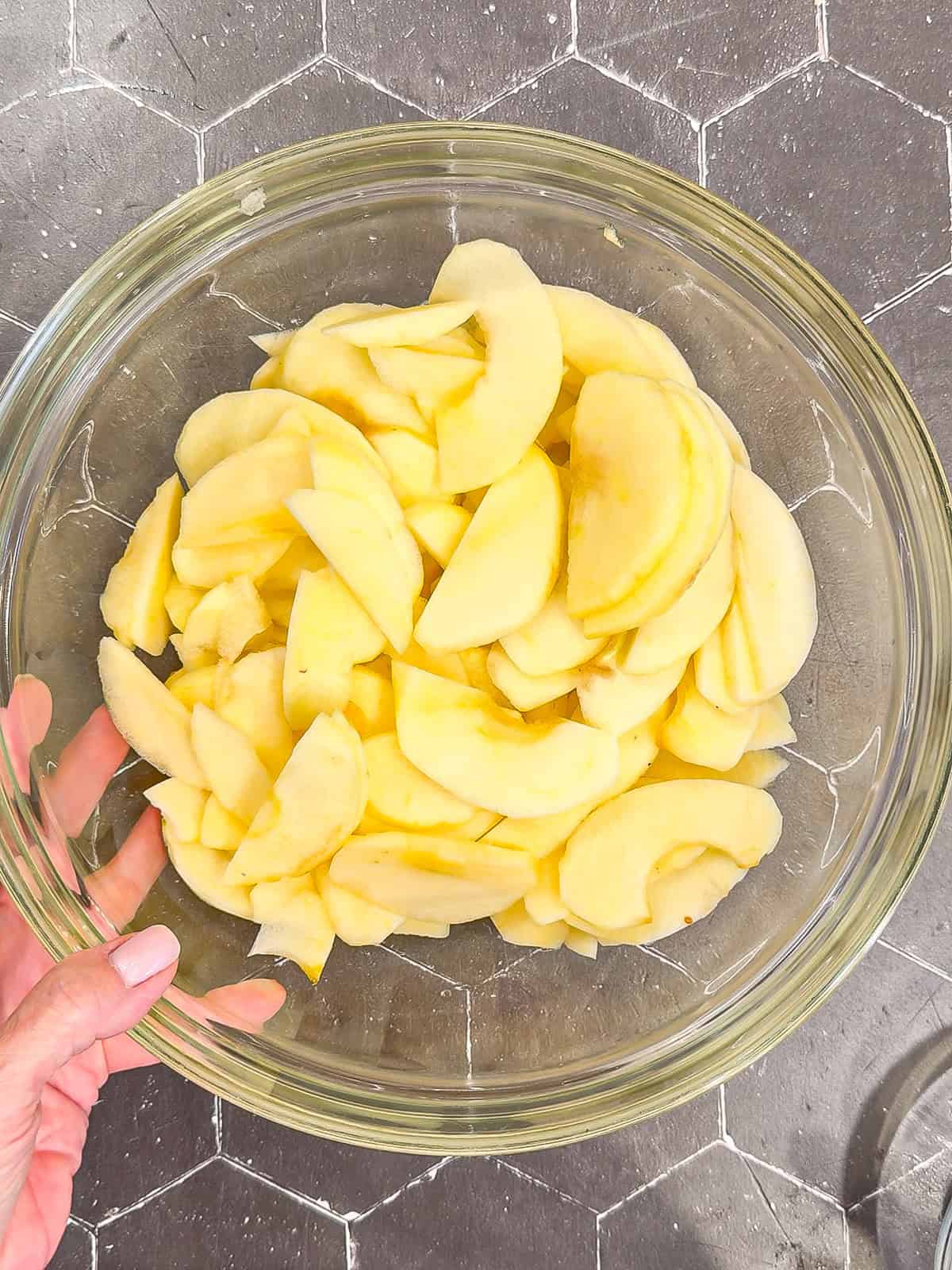 Sliced apple apples in a glass bowl.