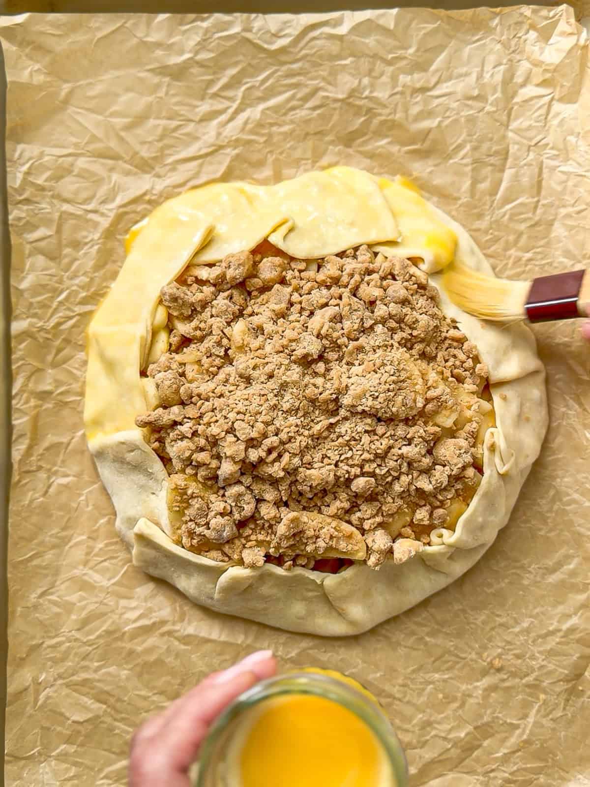 Brushing an egg wash on an apple streusel Gillett.