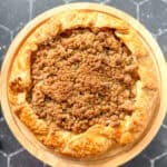 Apple streusel galette on a cake stand.
