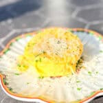 A microwave omelette with grated Parmesan and fresh chives on a scalloped plate.